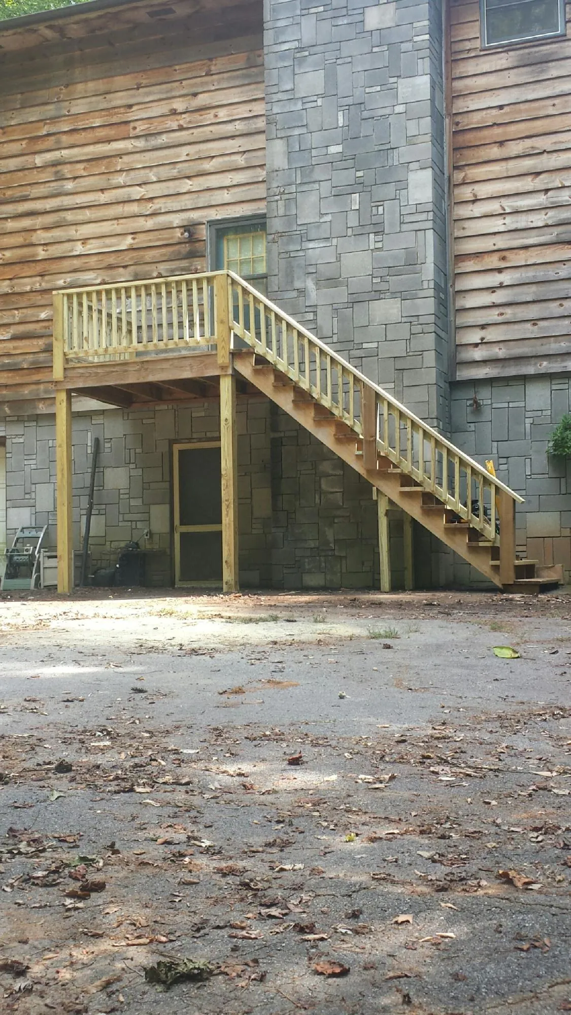 New pressure treated deck and stair landing on a log home in Kremmling